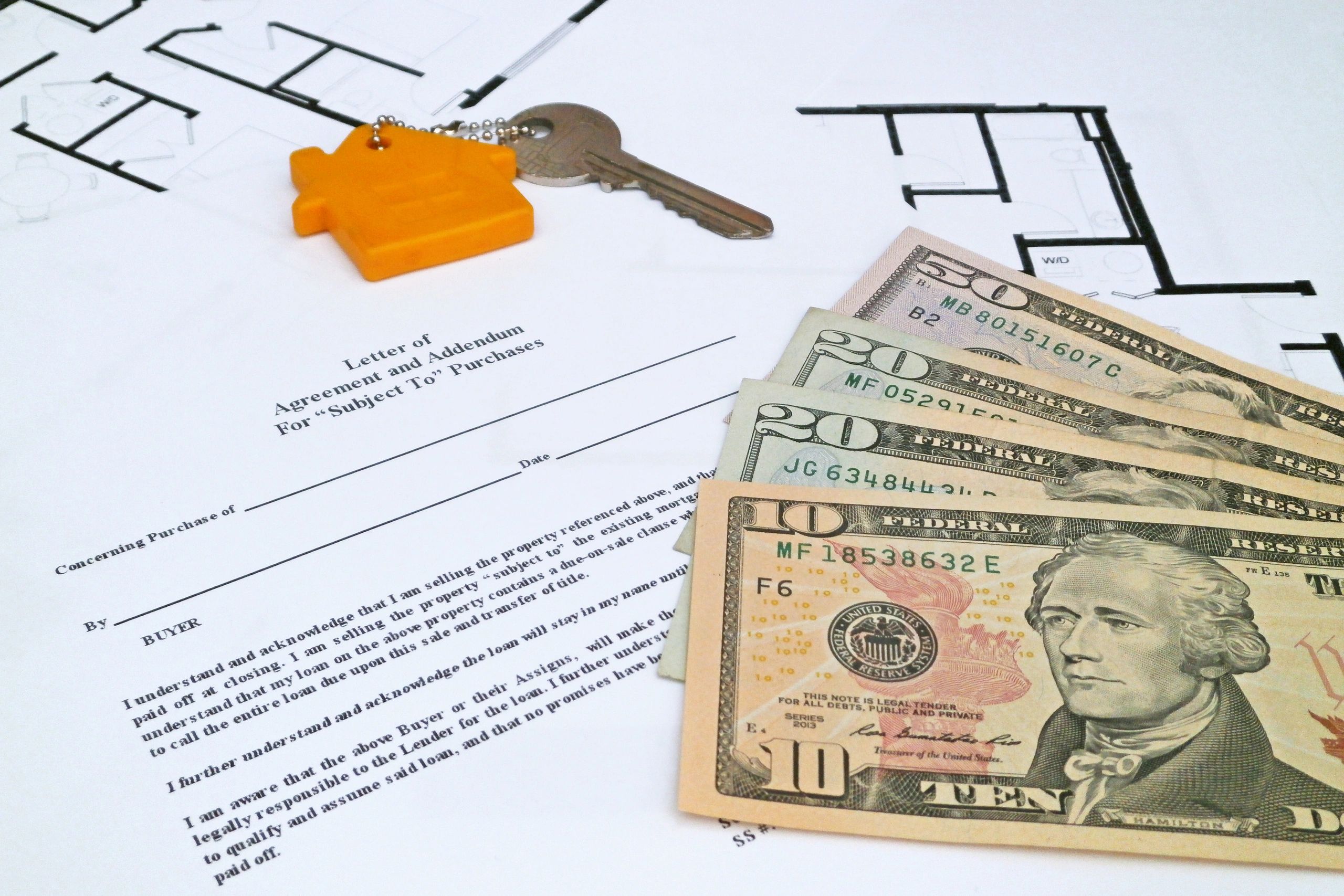 Real estate closing documents with key and plans